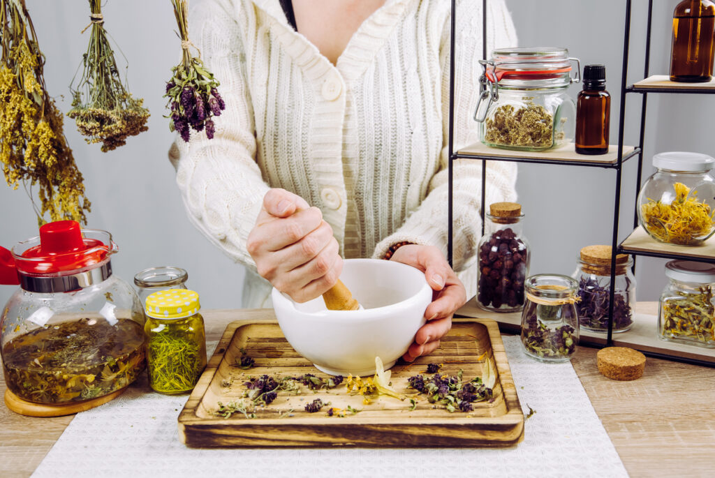 Close up view of woman herbalist mixing various dried herbs
