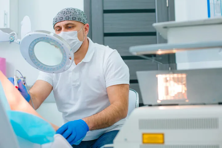 doctor examines the varicose veins on a patient