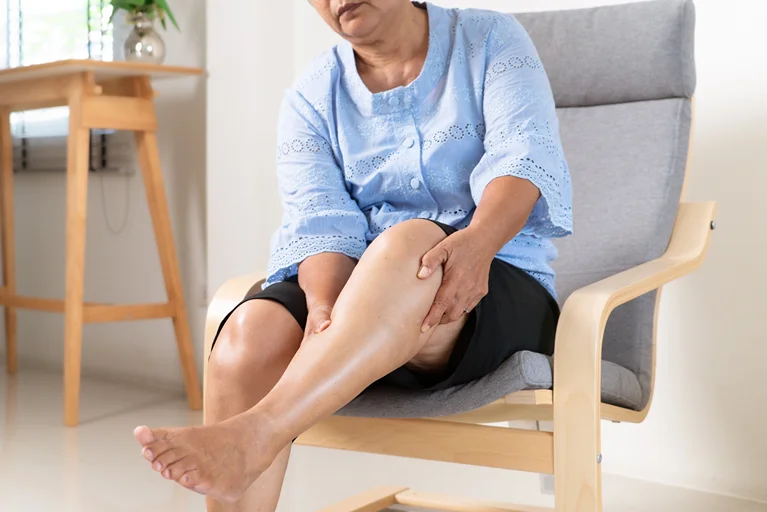 Old woman suffering with leg pain due to vein problems