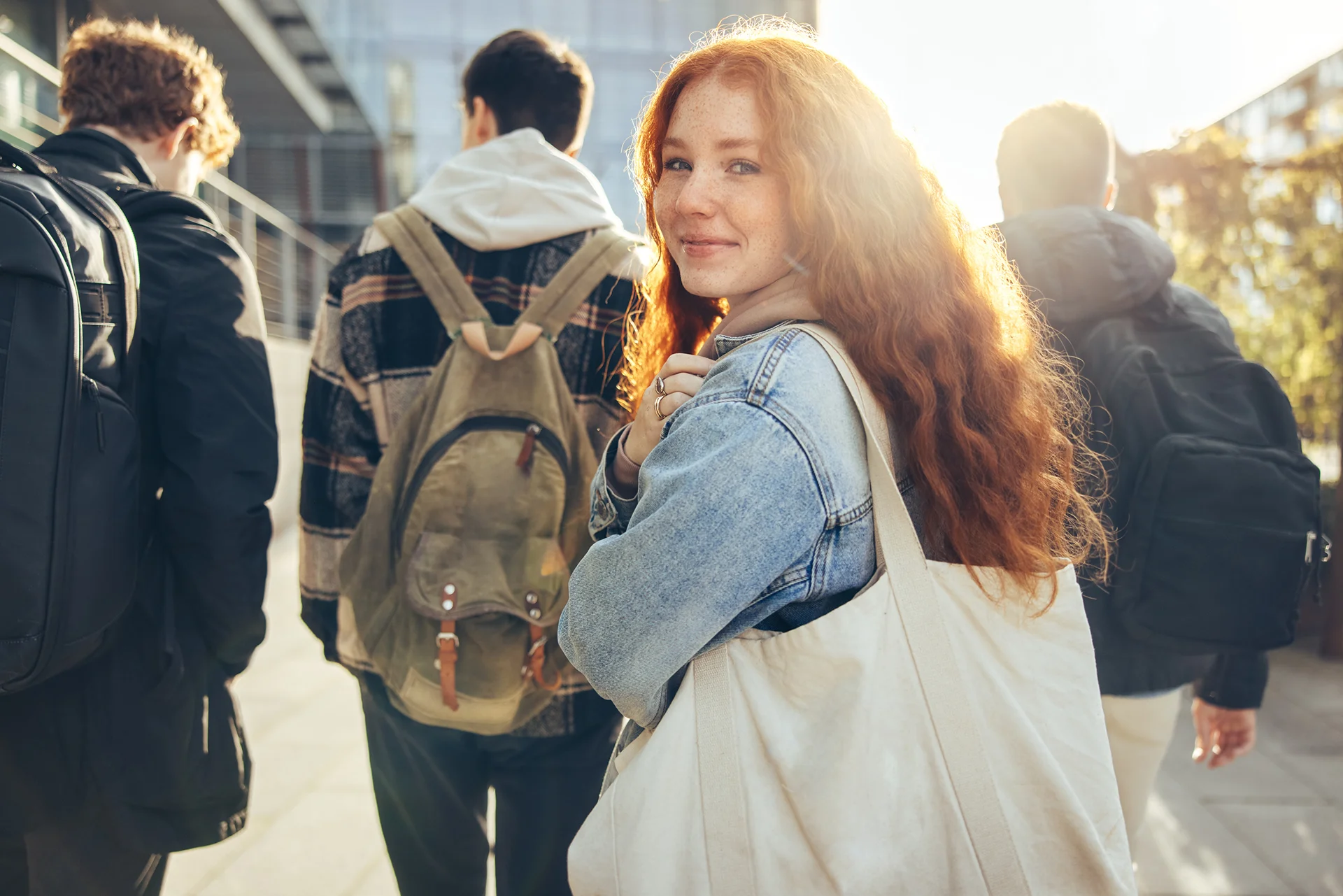 Young girl walking behind young boys