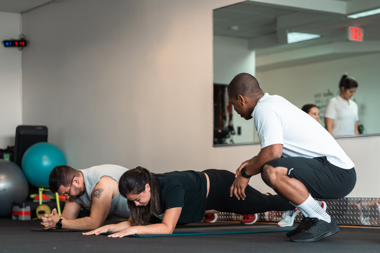 People working out in the gym with a personal trainer